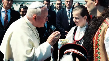 Na archívnej snímke pápež Ján Pavol II.(vľavo) dáva požehnanie mladému páru v kroji, ktorý pápeža privítal na letisku M. R. Štefánika v Bratislave tradične soľou a chlebom. 