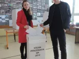 Na snímke zľava volička Júlia Čahojová a Filip Čahoj, ktorí prišli na Slovensko zo zahraničia, vhadzujú hlasovací lístok do volebnej schránky vo volebnej miestnosti na ZŠ Alexandra Dubčeka na Majerníkovej ulici v Bratislave počas 1. kola prezidentských volieb v sobotu 16. marca 2019.