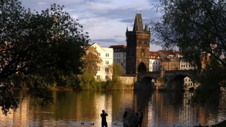 Na snímke muž fotografuje Karlov most na brehu rieky Vltavy v českej metropole Prahe