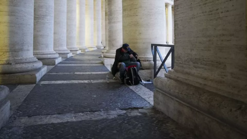 Na snímke bezdomovec sa ukladá k spánku pod Berniniho kolonádou na Námestí svätého Petra v Ríme