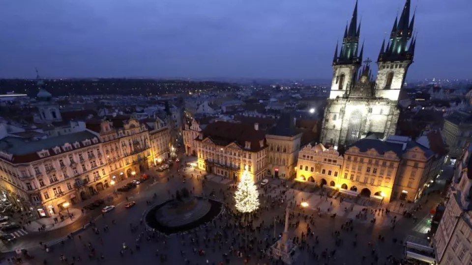 Ľudia stoja pri rozsvietenom vianočnom strome na Staromestskom námestí v Prahe