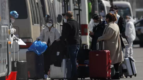 KK13 Peking - Pracovník v ochrannom odeve kontroluje cestujúcich pred nastúpením do autobusu pred novým čínskym medzinárodným výstavným centrom, ktoré slúži na kontrolu ľudí prichádzajúcich zo zahraničia 17. marca 2020 v Pekingu. Za uplynulý deň nahlásili v Číne 13 ďalších úmrtí  na ochorenie spôsobené koronavírusom  a 21 nových infikovaných. Z nich až dvadsiatim zistili ochorenie pri príchode do krajiny a sú tak v oficiálnej štatistike  vedení ako 