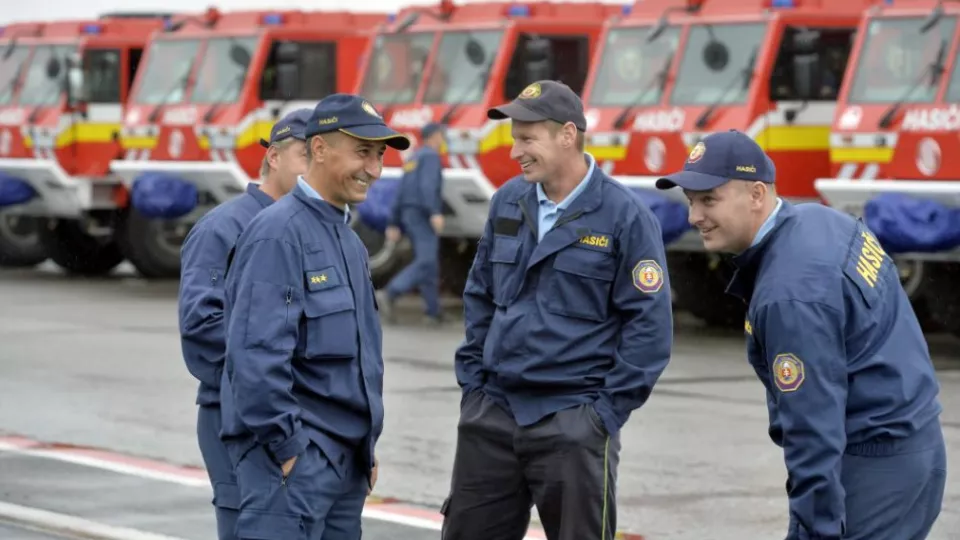 Na snímke pohľad na žartujúcich hasičov pred novými hasičskými vozidlami značky TATRA815-7.