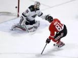 Hokejista Chicaga Blackhawks Marián Hossa strieľa gól za chrbát brankára Minnesoty Wild Darcymu Kuemperovi