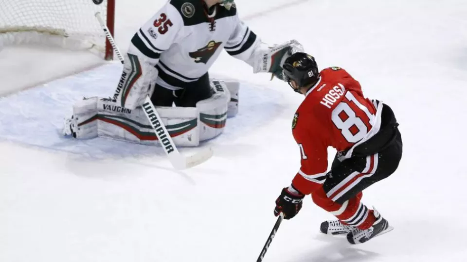 Hokejista Chicaga Blackhawks Marián Hossa strieľa gól za chrbát brankára Minnesoty Wild Darcymu Kuemperovi