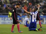 Futbalista Barcelony Lionel Messi (vľavo) kráča okolo radujúceho sa hráča Deportiva Raula Albentosu po výhre Deportiva nad Barcelonou 2:1.